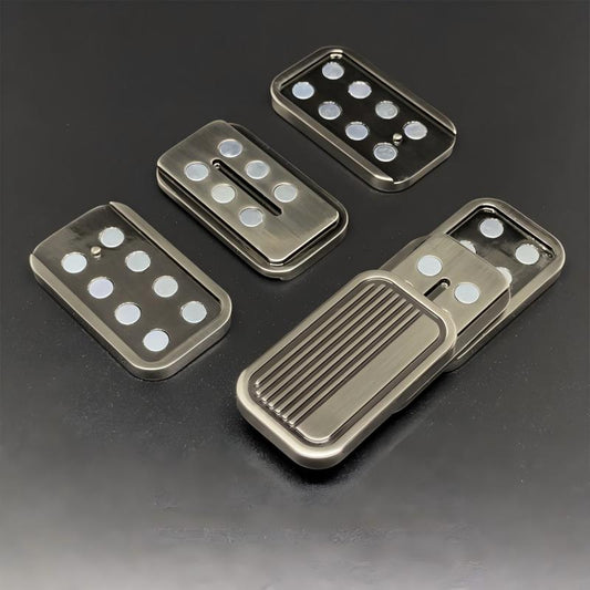 Set of metallic pedal covers with textured and smooth surfaces on a dark background