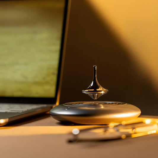 Spinning top toy on a desk with a laptop in the background