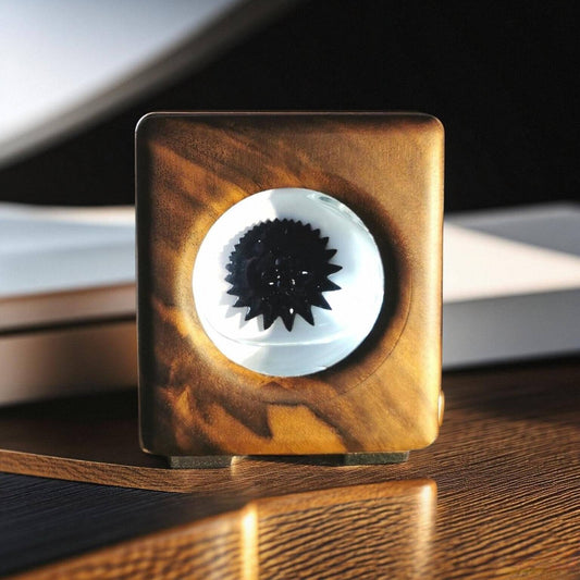 Wooden square object with a black and white center on a reflective surface
