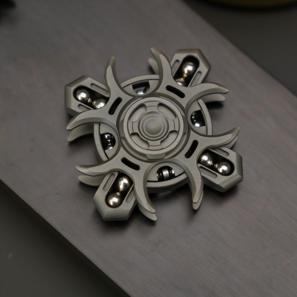 Metallic fidget spinner on a reflective surface