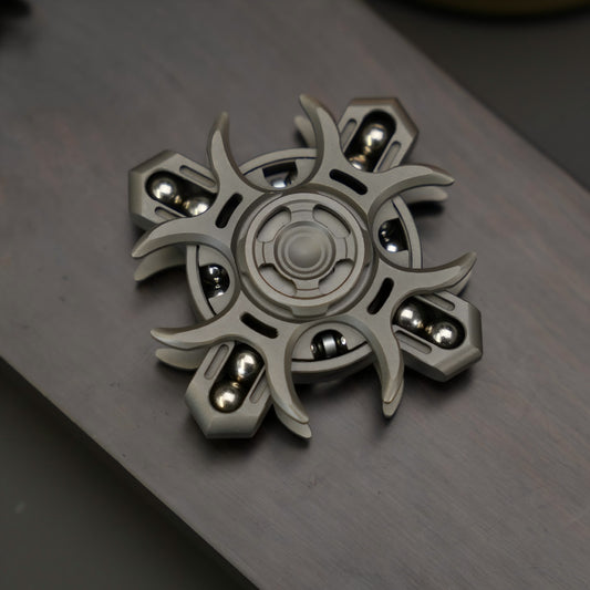 Metallic fidget spinner on a reflective surface