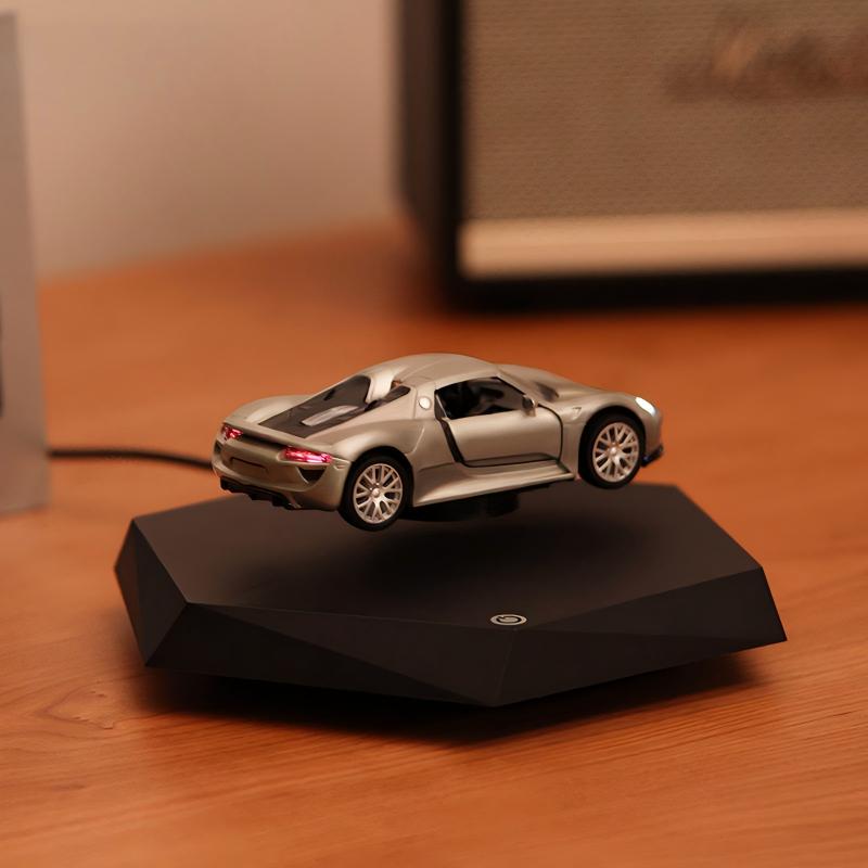 Silver toy car on a black magnetic stand on a wooden surface