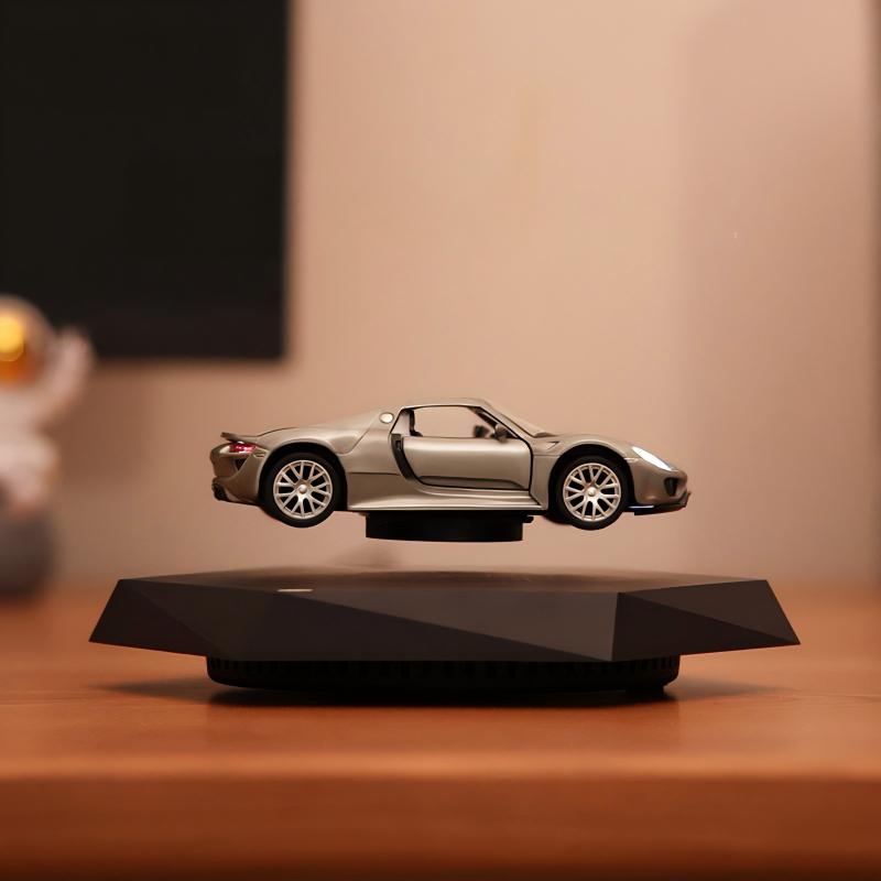 Silver toy car levitating on a black stand against a warm-toned background