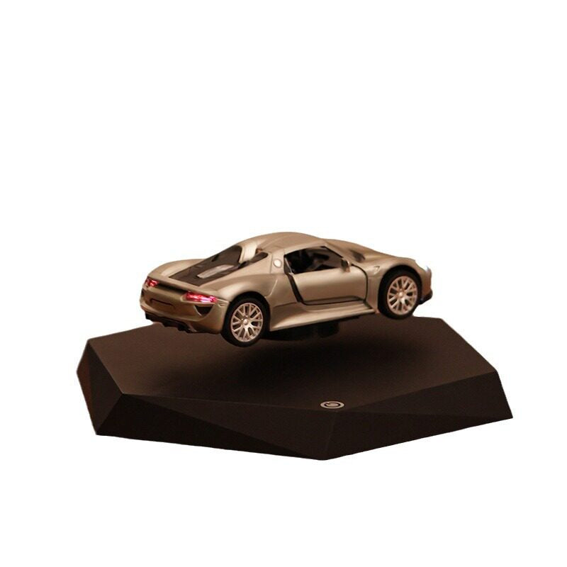 Gold sports car model on a black stand with a white background