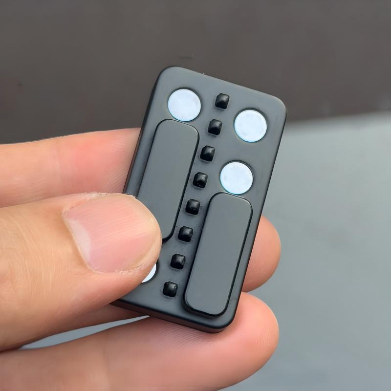 Small electronic device held in a hand with a neutral background