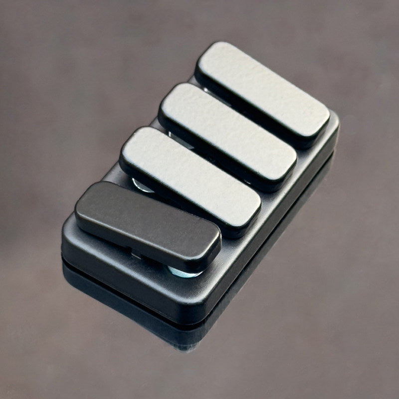 Metallic guitar pickguard with five rectangular slots on a gray background