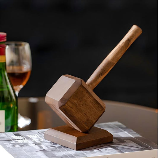 Wooden mallet on a table with a glass of wine and bottle in the background