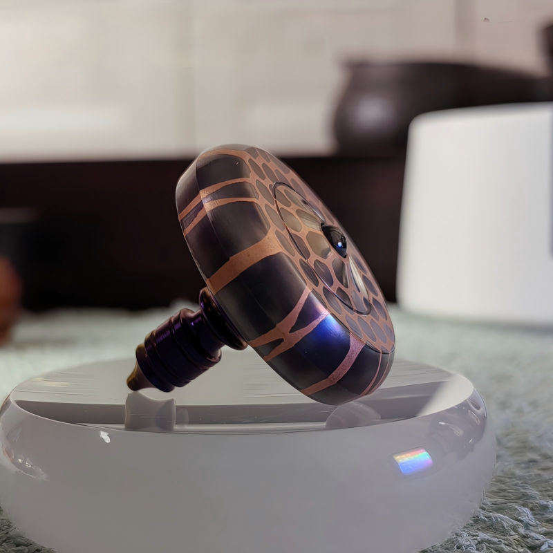 Titanium Niobium Fidget Spinner | Premium Metal Stress Relief Toy | Desktop Gift on a reflective surface.