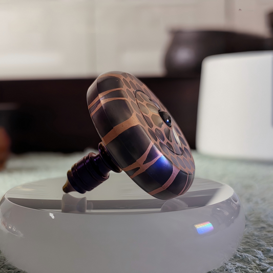 Titanium Niobium Fidget Spinner | Premium Metal Stress Relief Toy | Desktop Gift on a reflective surface.